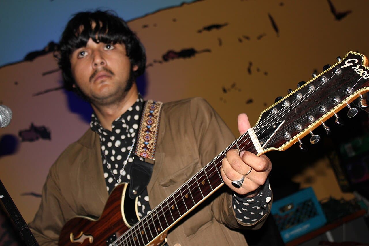 A guitarist with a vintage 12-string on a small stage